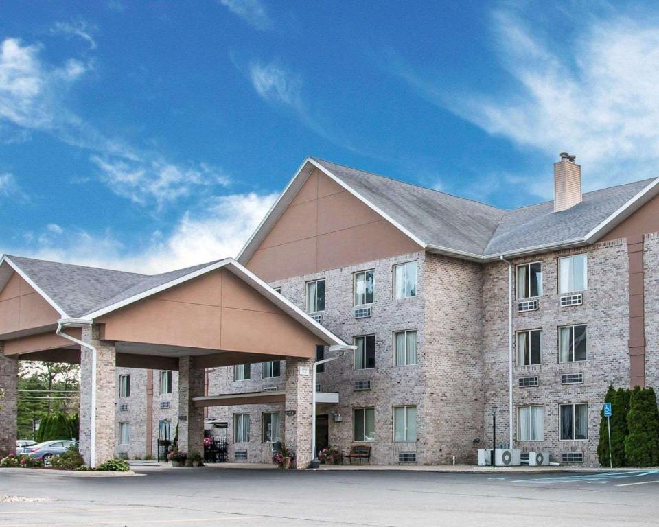 a large brick building with a blue sky in the background at Comfort Inn Whitehall near Michigan's Adventure in Whitehall