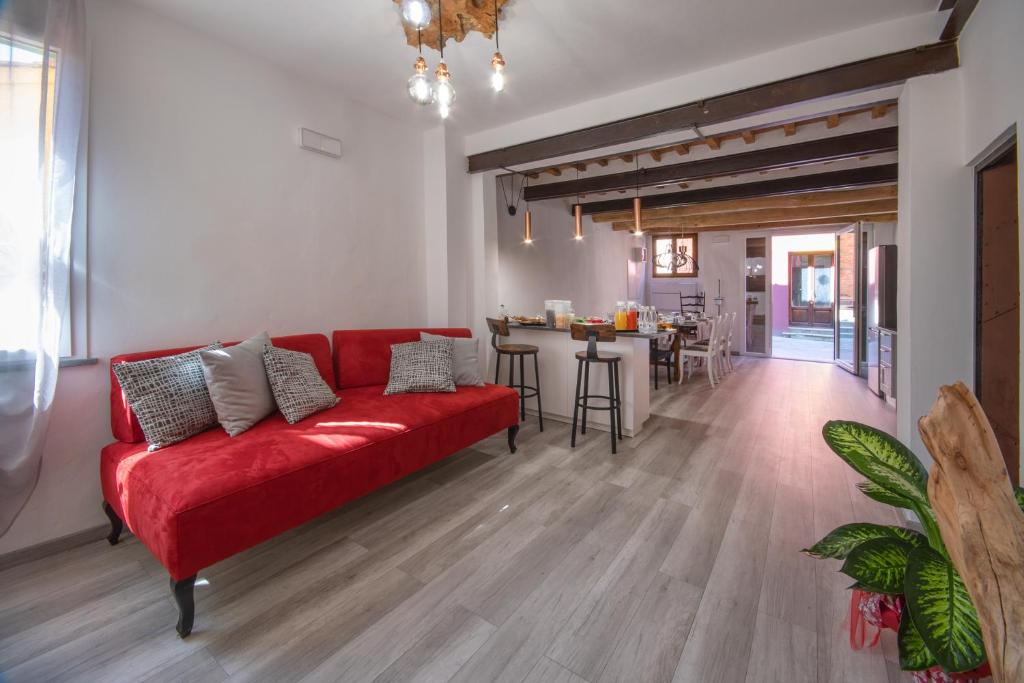 salon z czerwoną kanapą i stołem w obiekcie B&B da Baba w mieście Ghizzano