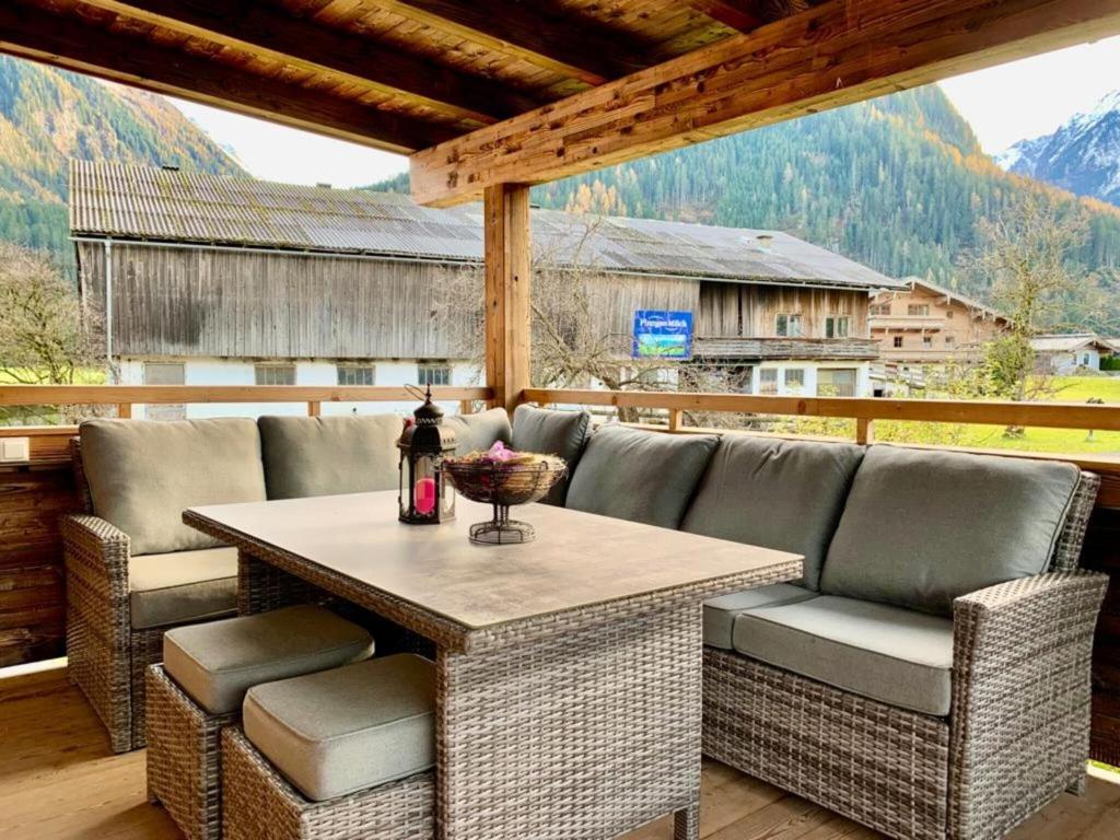 patio ze stołem i krzesłami na tarasie w obiekcie Flat with whirlpool near the Wildkogel ski area w mieście Neukirchen am Großvenediger