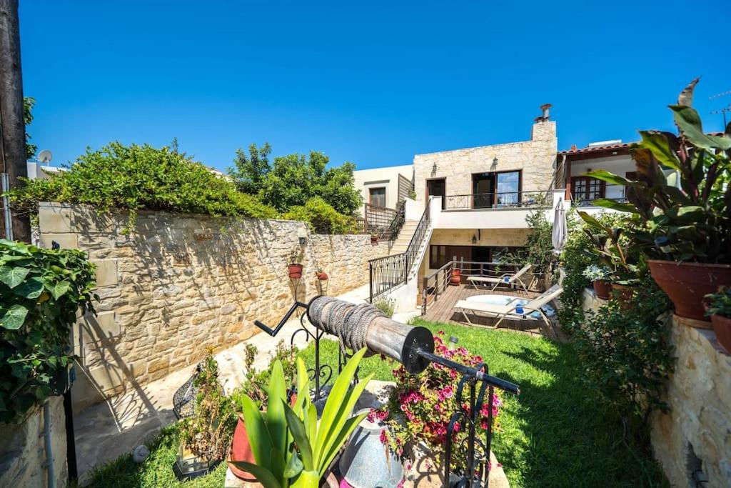 Blick auf ein Haus mit einer Kanone im Hof in der Unterkunft Arhontariki Luxury Apartment in Panormos