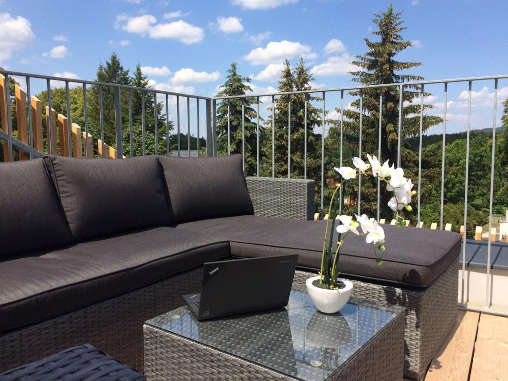 a couch and a table with a laptop on a balcony at All about the Lake in Staré Splavy