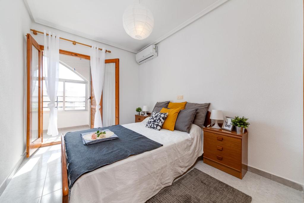 een slaapkamer met een groot bed en een raam bij Cozy Apartment near the sea in Torrevieja