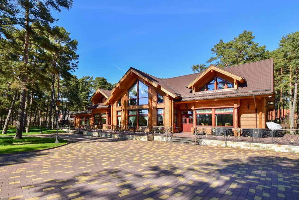 une grande maison en bois avec une allée en briques dans l'établissement Villa Lohusalu, à Lohusalu