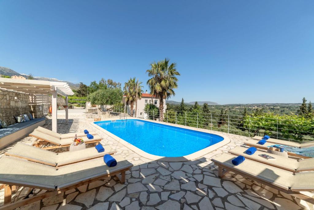 Villa con piscina y tumbonas en Villa Chrysallis with heated pool, en Georgioupolis