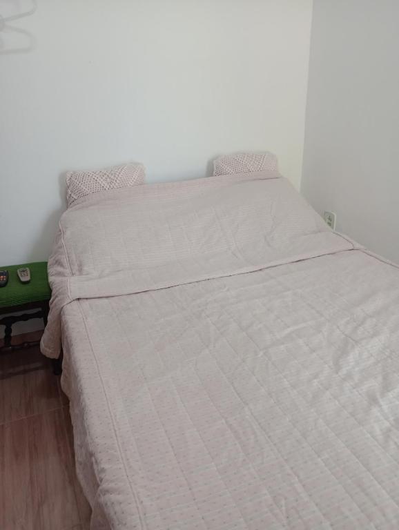 a bed in a bedroom with a white bedspread at Recanto das Videiras in Maria da Fé