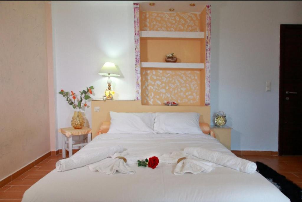 a bedroom with a large white bed with towels on it at Kosmira Big House in Ioannina