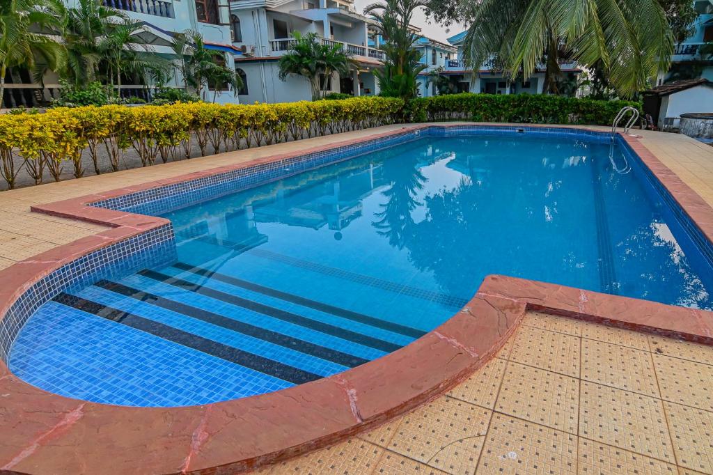 a large swimming pool with blue water at GR Stays - Duplex 3bhk Villa With Pool Arpora I Baga Beach 5 mins in Arpora