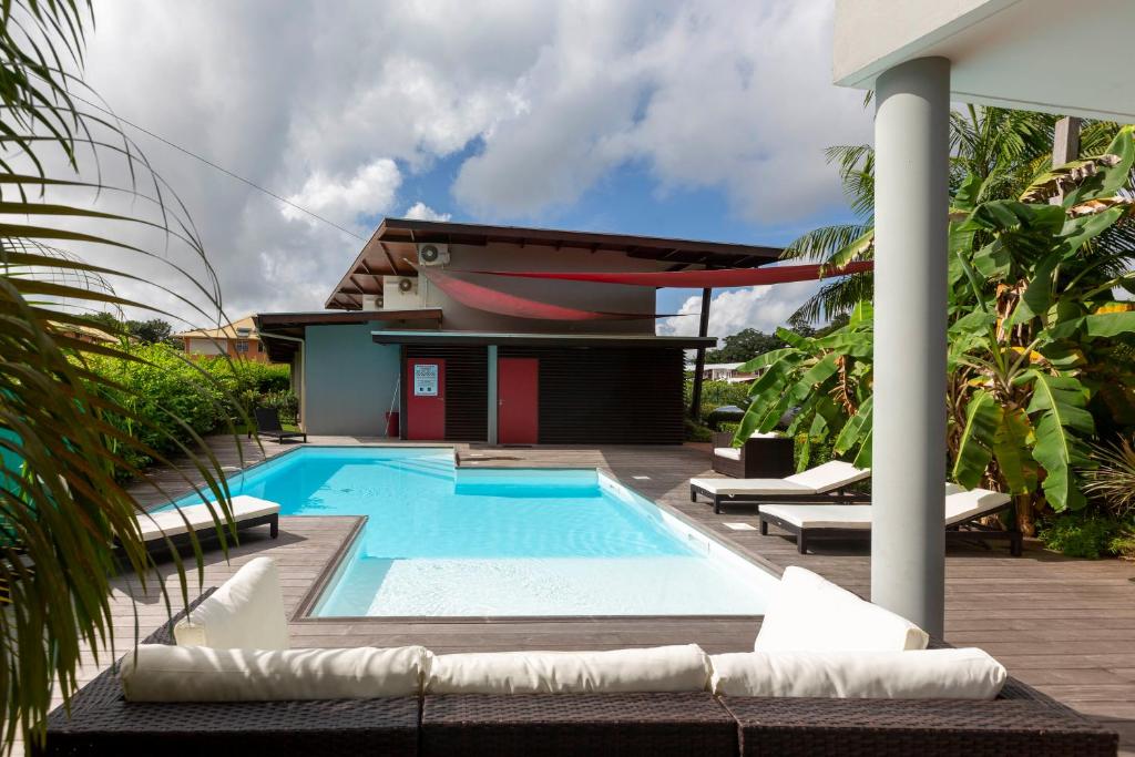 a swimming pool in front of a house at Résidence HIBISCUS 5 étoiles in Cayenne
