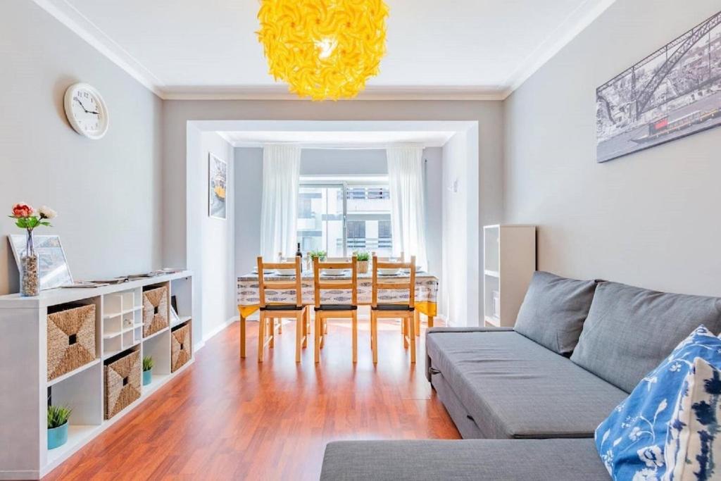 a living room with a couch and a table and chairs at Apartamento Lar doce Lar Porto in Vila Nova de Gaia