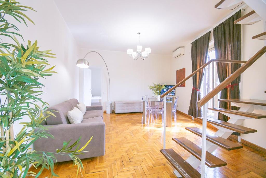 a living room with a couch and a staircase at Penthouse in the heart of the city center in Rome