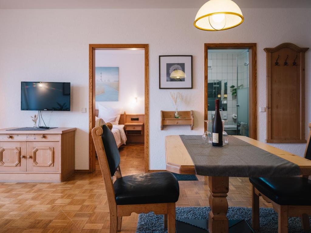 ein Wohnzimmer mit einem Esstisch und ein Schlafzimmer in der Unterkunft Landhaus Weber in Bad König