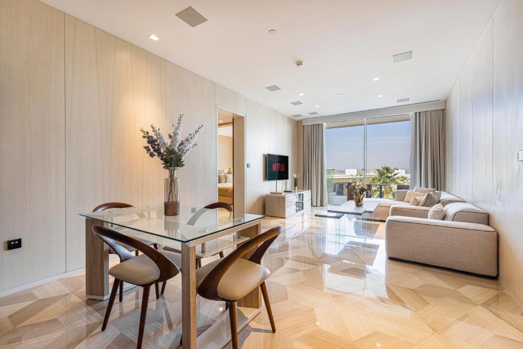 杜拜的住宿－Lavish Sea View 2BR with M at Five Palm，客厅配有玻璃桌和椅子