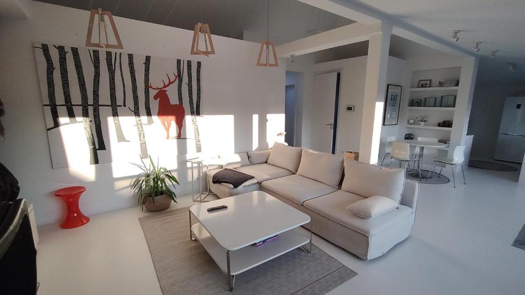 uma sala de estar com um sofá e uma mesa em loft 85 m2 Wilanow Krolewski self checkin em Varsóvia