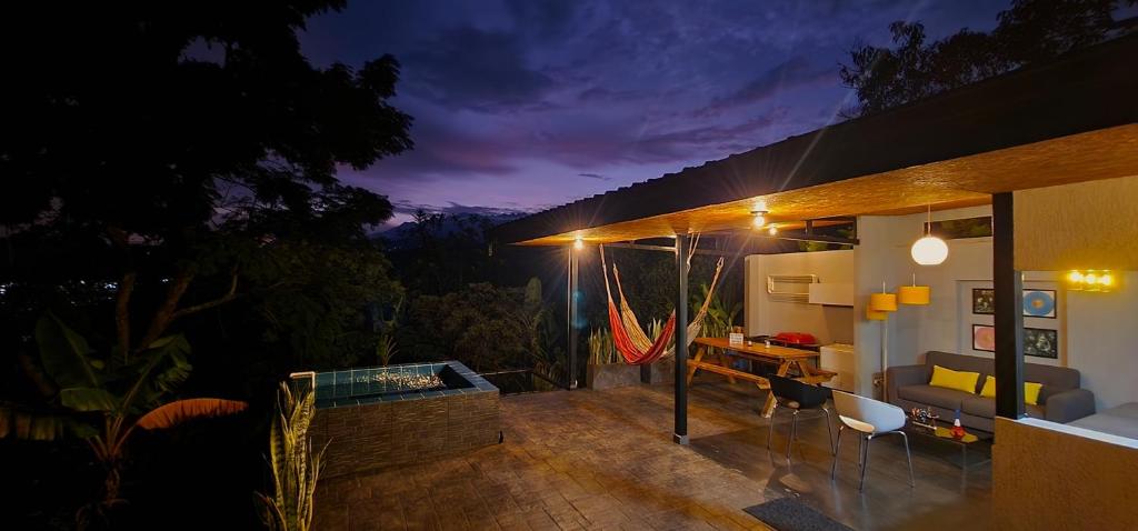 Cette maison dispose d'une terrasse avec un canapé et une table. dans l'établissement Glamping Gaia Origen en Cali - Cabaña y Domo Geodésico a 10 min de los Gatos del Río, à Cali