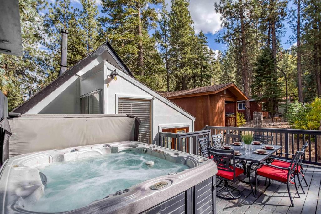 a hot tub on a deck with a table and chairs at 019 - Almost Heaven in Big Bear Lake