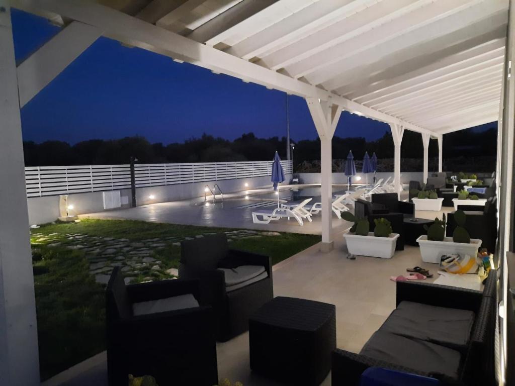 a patio with couches and chairs at night at Perladelmare in Avola