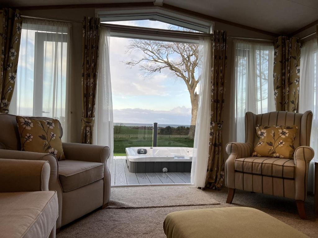 sala de estar con ventana grande y bañera en Stewarts Resort Lodge 31 en St Andrews