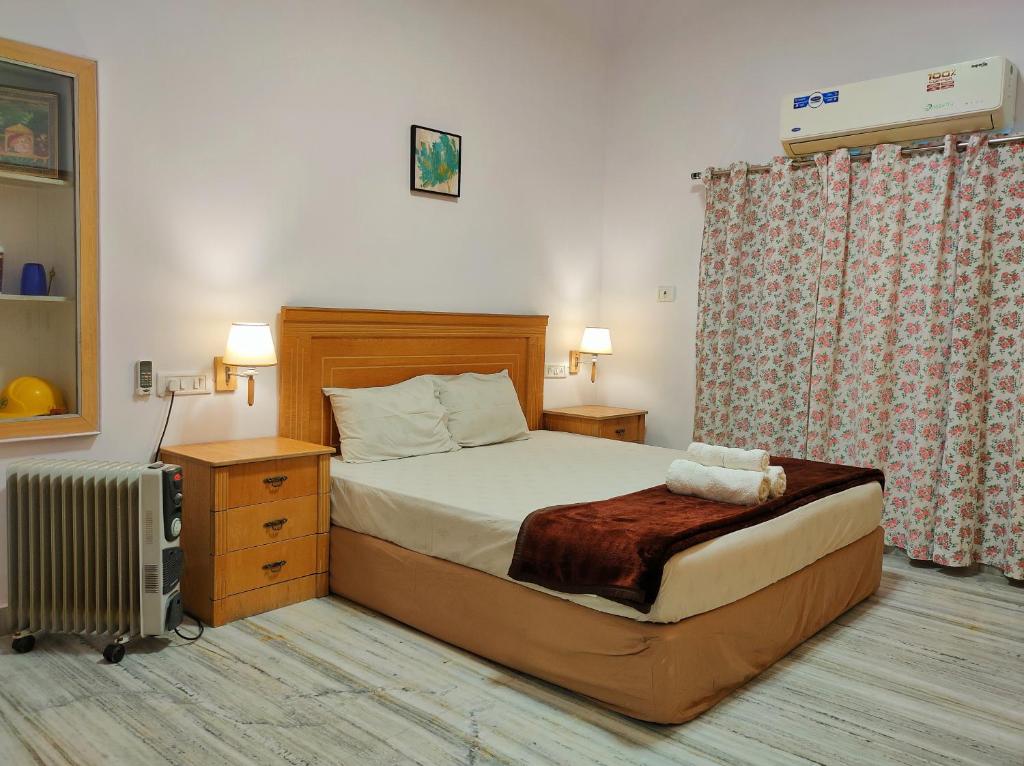 a small bedroom with a bed and a radiator at Homestay at Bungalow 97 Ajmer in Ajmer