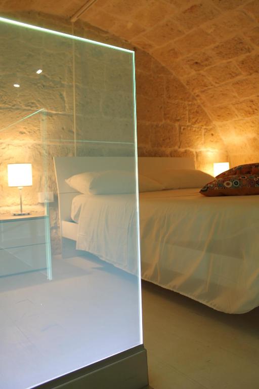 - une chambre avec un lit et une paroi en verre dans l'établissement Tell me why Puglia, à Corato