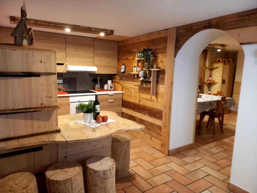 cocina con paredes de madera y encimera con mesa en Botton d'oro en Campitello di Fassa