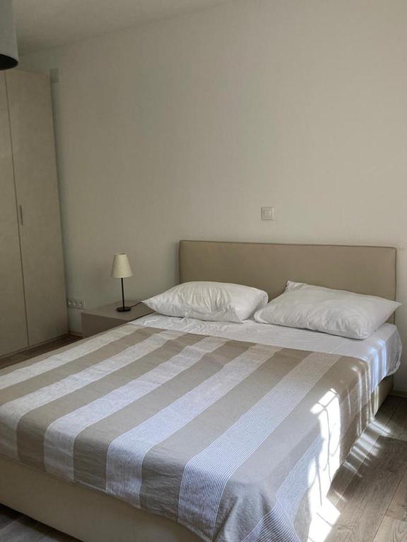 a bedroom with a large bed with a striped blanket at Ribarska Koliba - Villa Marija in Pula