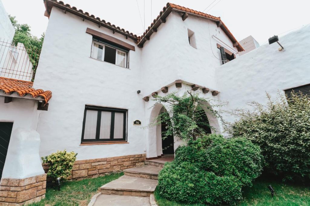 una casa blanca con un arco en un patio en Anden Espejo en Mendoza