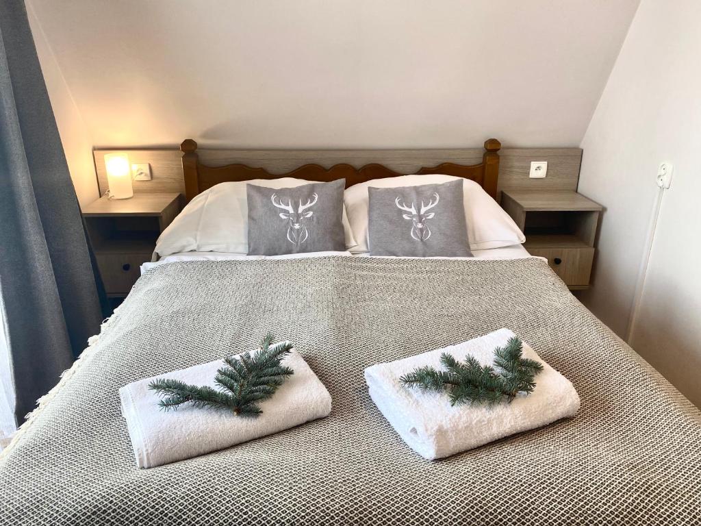 a bed with two christmasmas pillows on it at Dom Wypoczynkowy Julia in Białka Tatrzańska