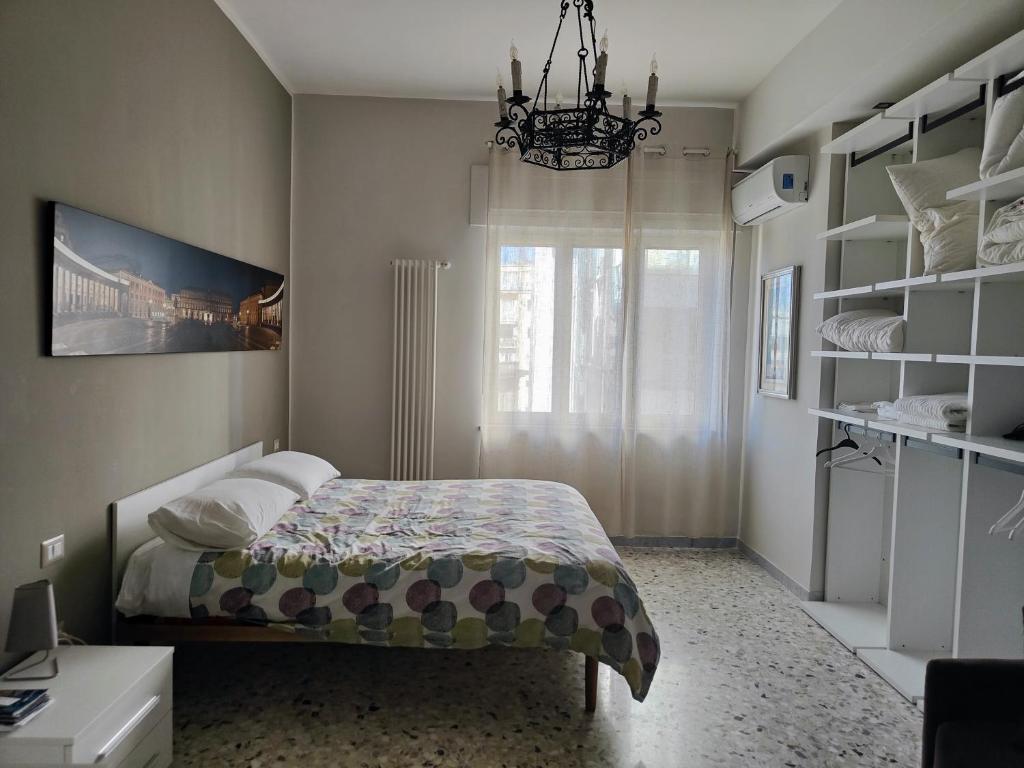 1 dormitorio con cama y lámpara de araña en La Dimora dell'Avvocato, en Nápoles