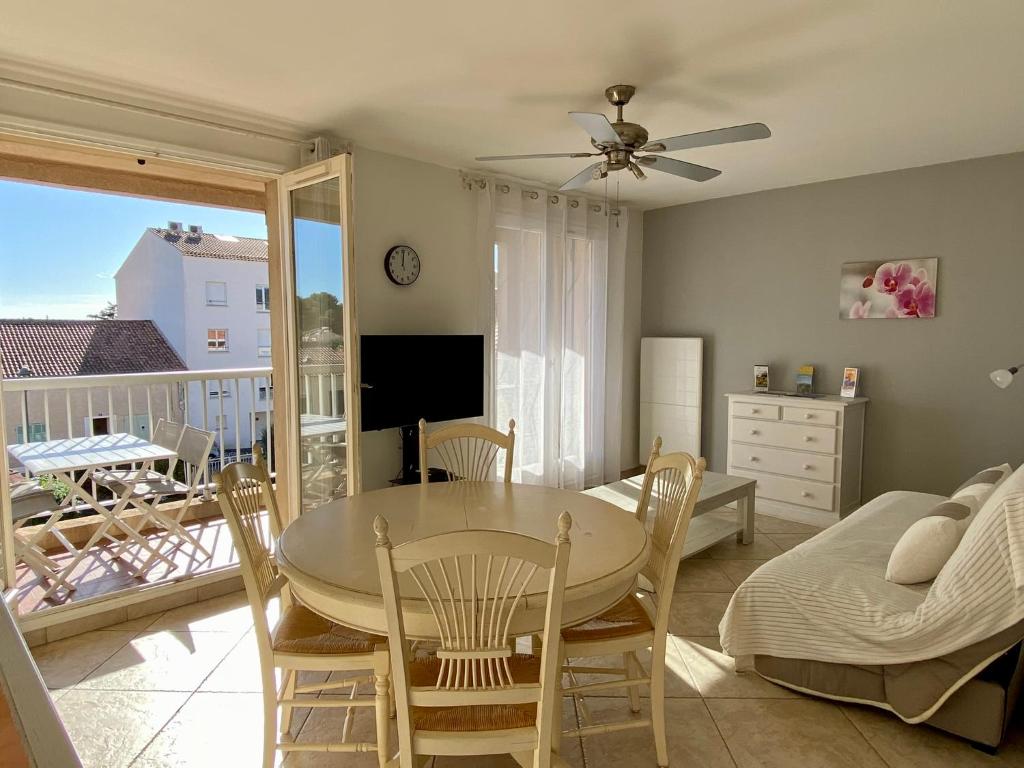 a dining room with a table and chairs and a balcony at Les locations Cinaureva "Les Îles d'Or" in La Londe-les-Maures