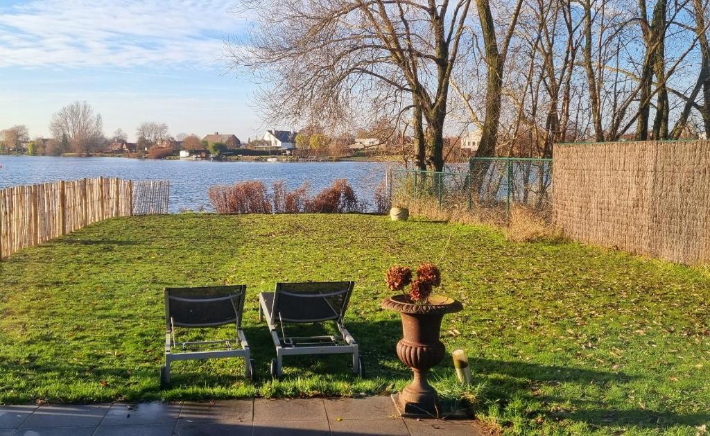 two chairs and a statue next to a lake at Cozy house at the lake in Nazareth