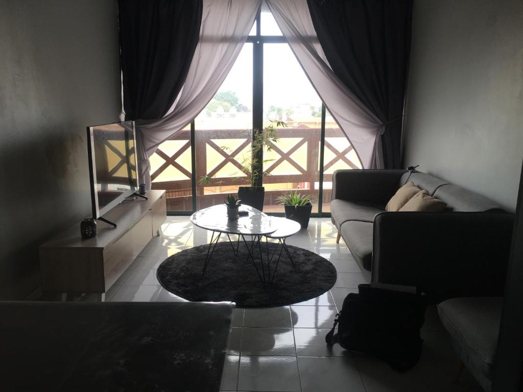 a living room with a table and a couch at The Grayish Melaka in Melaka