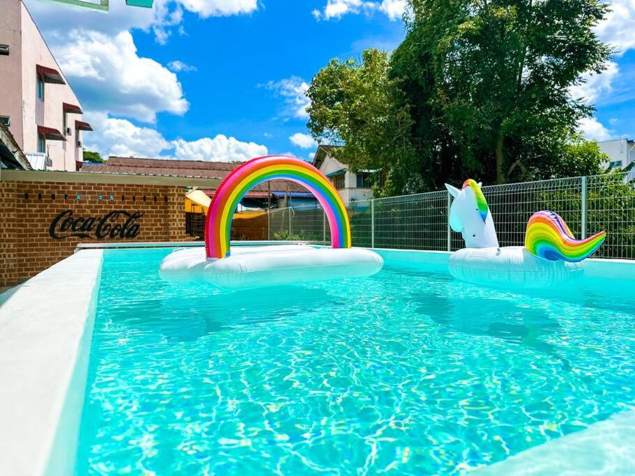 a swimming pool with a rainbow and two inflatables at Kluang Swimming Pool Blues 11 Retro Homestay in Kluang