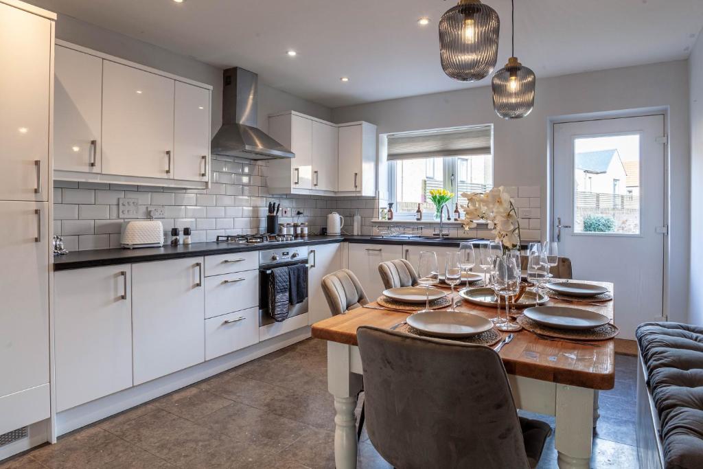 uma cozinha com uma mesa e cadeiras numa cozinha em Modern 3 bedroom spacious house with parking em Bath