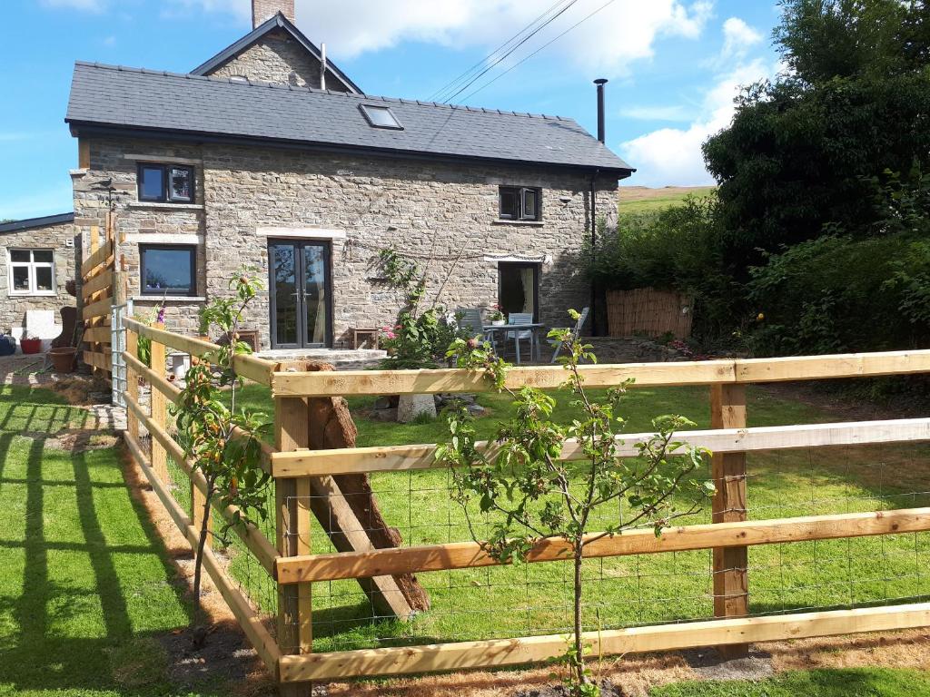 a wooden fence in front of a stone house at Buzzards Breg in Builth Wells