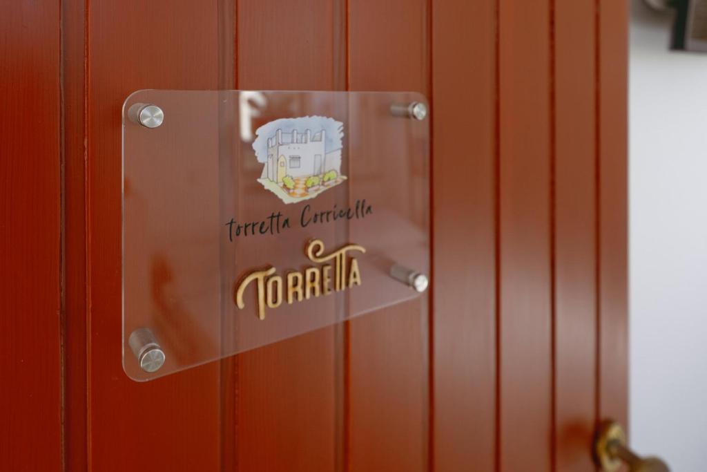 un cartel en una puerta con las palabras toraja canada en TORRETTA CORRICELLA- Torretta en Procida