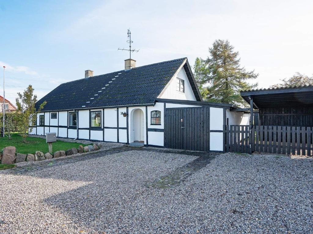 een wit en zwart huis met een zwart hek bij 8 person holiday home in Sakskøbing-By Traum in Sakskøbing