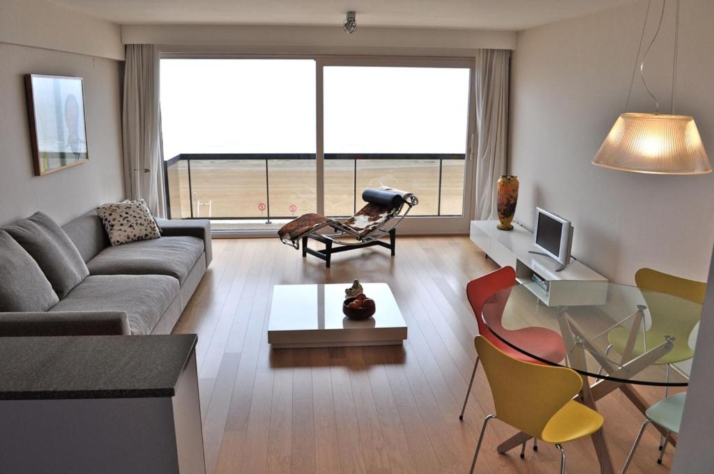 ein Wohnzimmer mit einem Sofa und einem Tisch in der Unterkunft Residentie Sofia, Coxy-Beach, Iepenwal, Kraaienest, Atlantic, Royal, Miramar in Koksijde