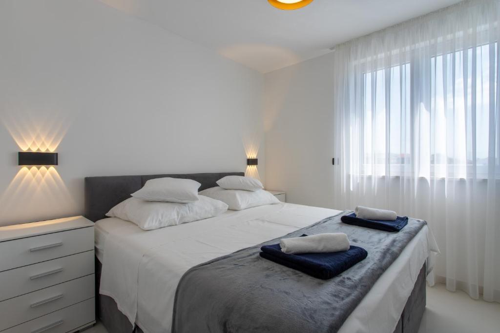 een slaapkamer met een groot bed en 2 handdoeken bij Luxury Apartment Viktoria Trogir in Trogir