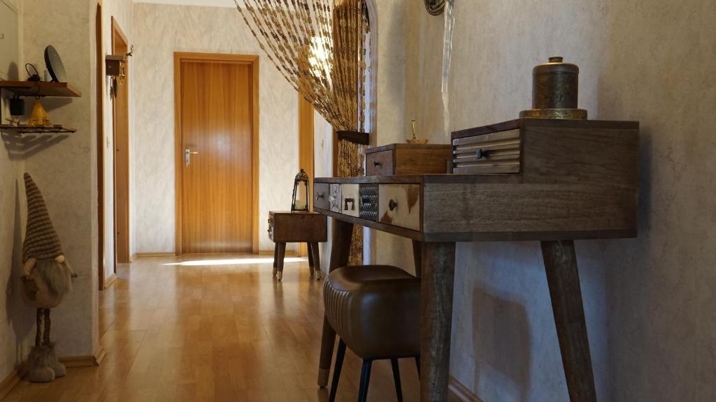 a room with a bar with a stool and a hallway at Großzügige Wohnung mit Terrasse und Gartenzugang. in Bindlach