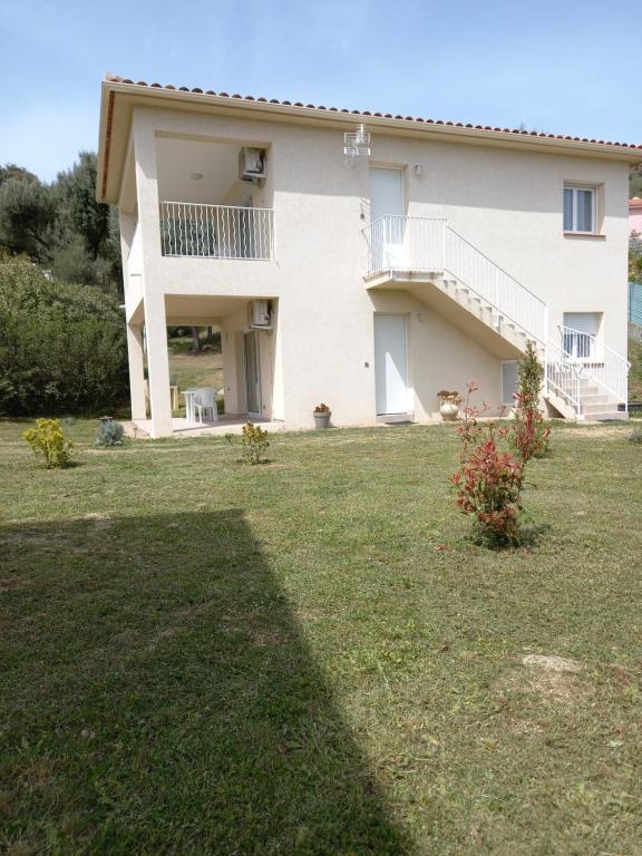 une grande maison avec une cour en face dans l'établissement U MANDARINU, à Ajaccio