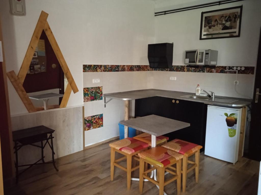 a kitchen with a counter and a table and a sink at Málnás Szállás in Dunavarsány