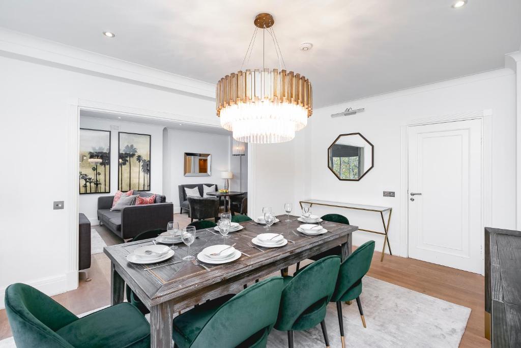 a dining room with a table and green chairs at ' Luxury & Spacious AirConditioned 4 Bed 4 Bath Apartment ' in London