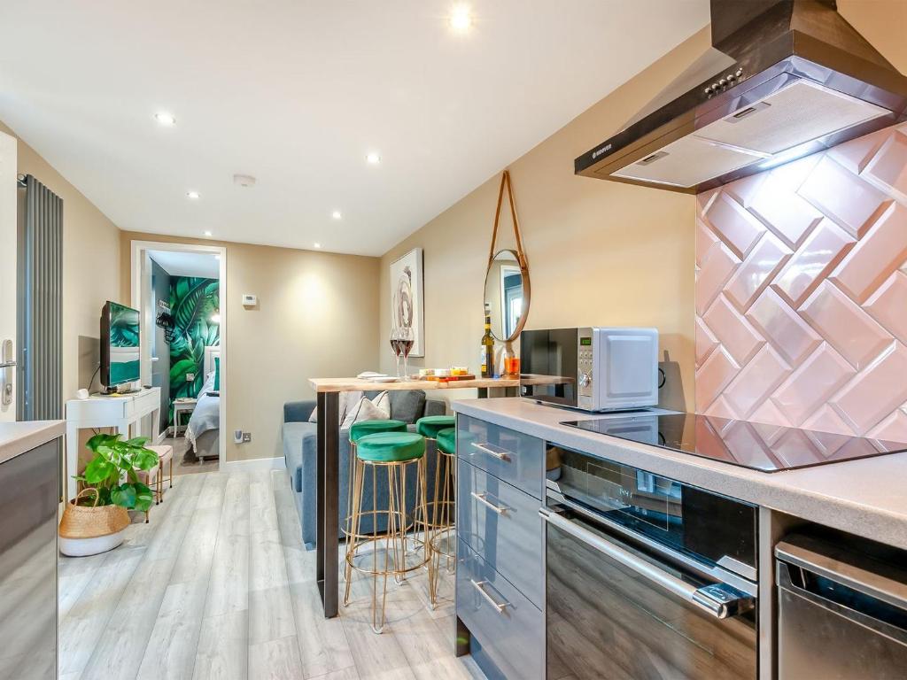 a kitchen with a counter and a stove top oven at Vitamin Sea Residency in Herne Bay