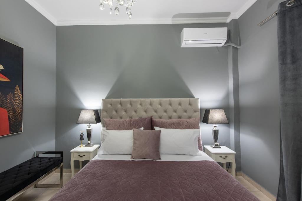 Luxury katrinas apartment with outdoor jacuzzi في مدينة كورفو: غرفة نوم بسرير كبير مع مواقف ليلتين
