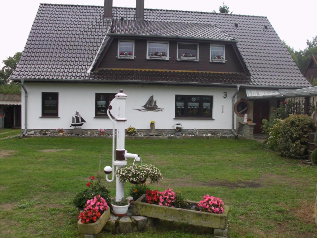 a white house with a yard with flowers at Darß Stuv in Born