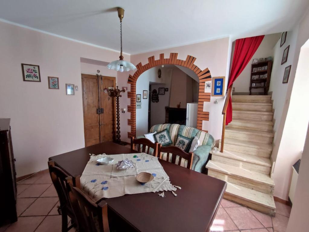 comedor y sala de estar con mesa y sillas en Casa Vacanza Nonna Maria, en Calvi dellʼ Umbria