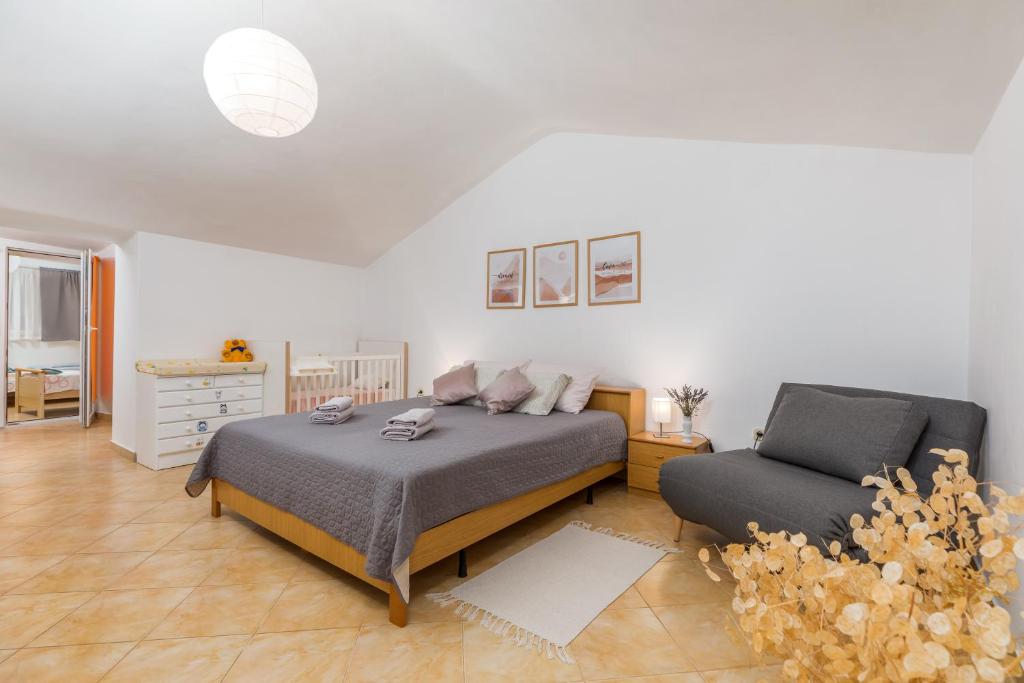 sypialnia z łóżkiem i krzesłem w obiekcie Apartment Dignano w mieście Vodnjan