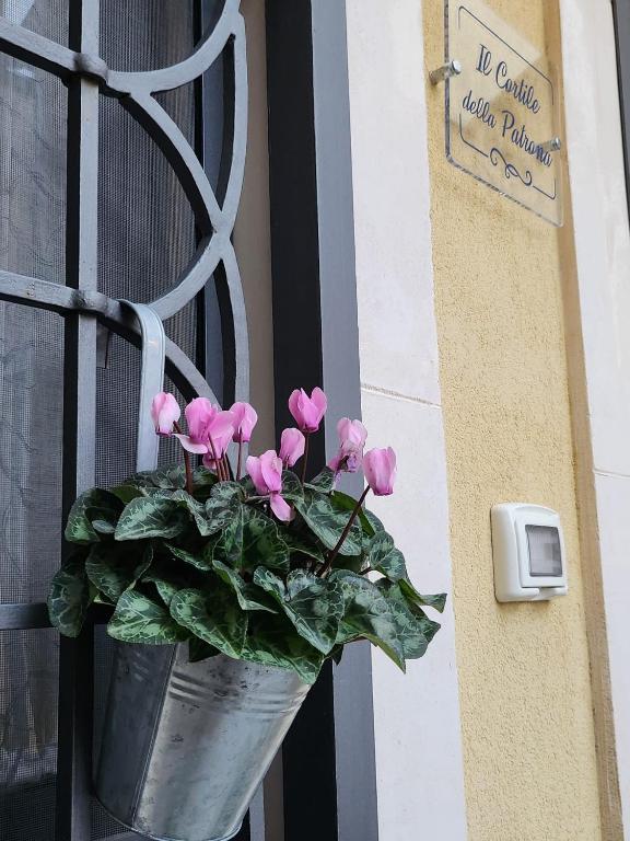 a pail with pink flowers in it on a door at Il Cortile della Patrona in Syracuse