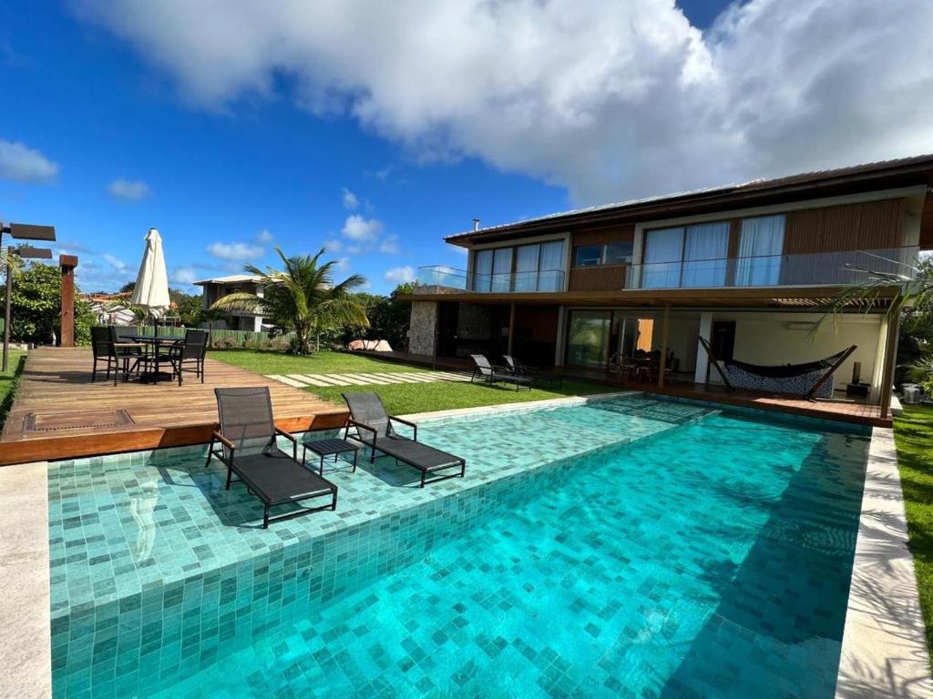 une villa avec une piscine et une maison dans l'établissement Casa em Praia do Forte - Bahia, à Praia do Forte