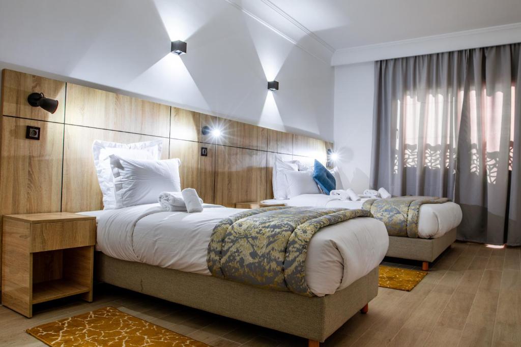 a hotel room with two beds and a large window at Karam City Hotel in Dakhla